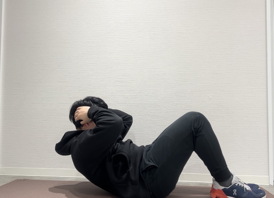 腹筋トレーニングの1つ「クランチ」をしているトレーナー