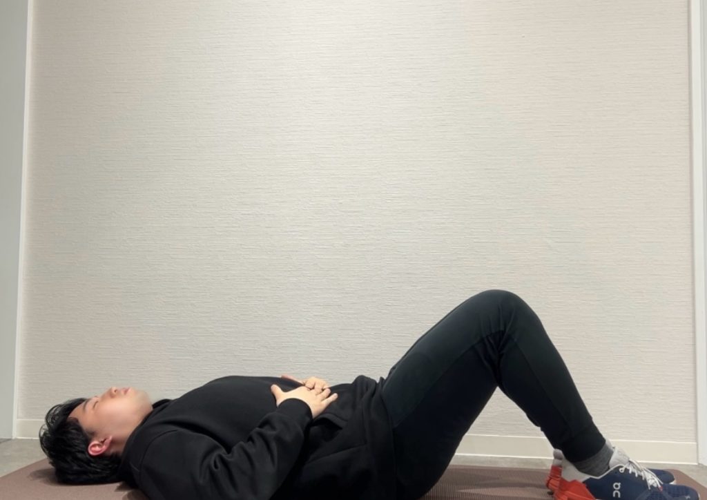 腹筋トレーニングの1つ「ドローイン」をしているトレーナー