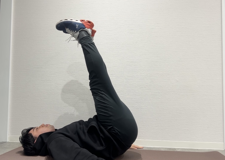 腹筋トレーニングの1つ「レッグレイズ」をしているトレーナー